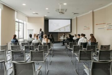 Un groupe assistant à une présentation commerciale dans une salle de conférence moderne avec projecteur.