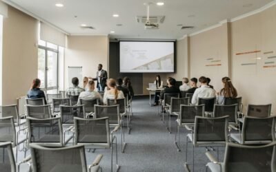 Un groupe assistant à une présentation commerciale dans une salle de conférence moderne avec projecteur.