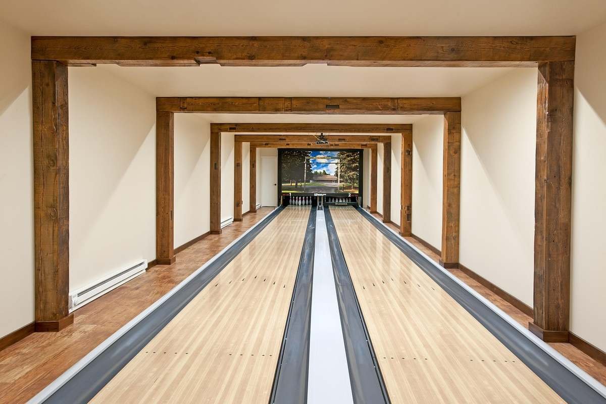 Allée de bowling avec pistes en bois poutres apparentes et écran final